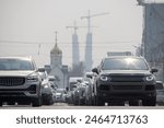 Cars on the roadway. In the distance is a chapel and the construction of supports for a cable-stayed bridge. Road traffic in a big city. Novosibirsk city, Novosibirsk region, Siberia, Russia.