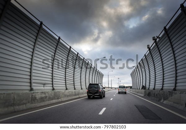 Cars on the\
sound-absorbing tunnel at the asphalt road. Metal structure with\
plastic parts. Modern\
technology.