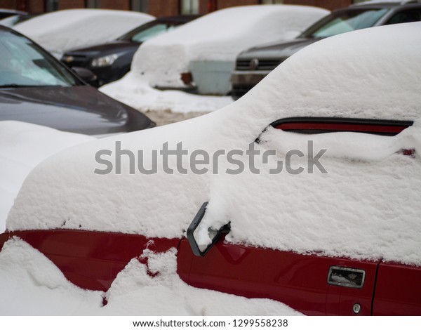 cars on the street covered with a large layer of\
snow after abnormal\
rainfall