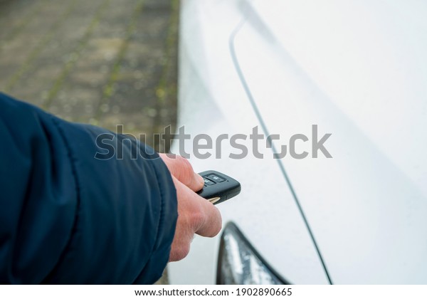 The car\'s owner pressing  Car Keys\
in the Hand sending signal to open the vehicle\
automatic.