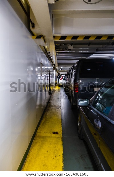 Cars are packed tight in on the car deck on a large\
car ferry