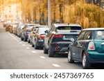 Cars parked at roadside in residential area, parking zone. Parking problems not enough free space. Crowded public parking lot on narrow street. Rows of cars parked on roadside