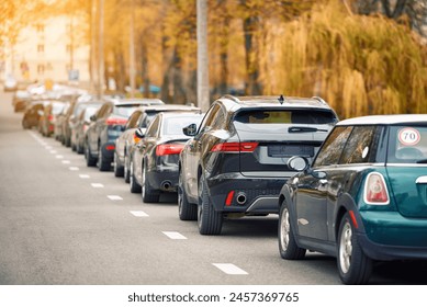 Cars parked at roadside in residential area, parking zone. Parking problems not enough free space. Crowded public parking lot on narrow street. Rows of cars parked on roadside - Powered by Shutterstock