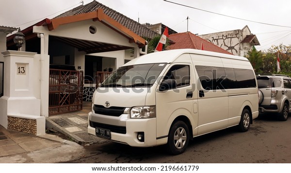 Car\'s parked in the yard.\
mini van hiace warna putih, kendaraan penumpang yang nyaman dan\
cocok untuk perjalanan wisata keluarga. Yogyakarta, Indonesia,\
September 1, 2022