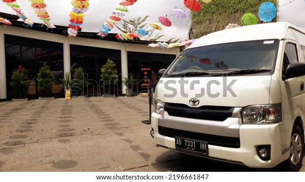Car\'s parked in the yard.\
mini van hiace warna putih, kendaraan penumpang yang nyaman dan\
cocok untuk perjalanan wisata keluarga. Yogyakarta, Indonesia,\
September 1, 2022