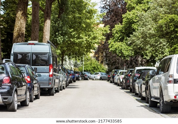Cars parking in line along both sides of road. Cars in\
parking lot. Busy parking lot at Traffic Jam. Free Parking Space\
Problem.   