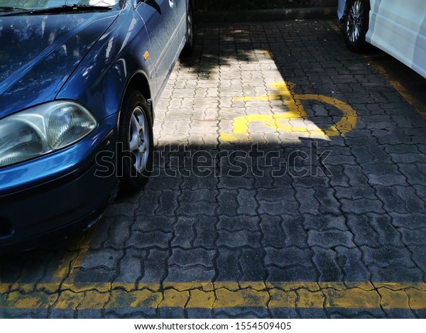 Cars parking on handicapped parking sign area at\
asphalt parking lot, special car parking area for handicapped\
people only, transportation convenience for disabled people\
concept.