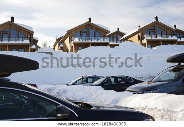 Cars parking in snowy parking lot in ski resort \
in Norway