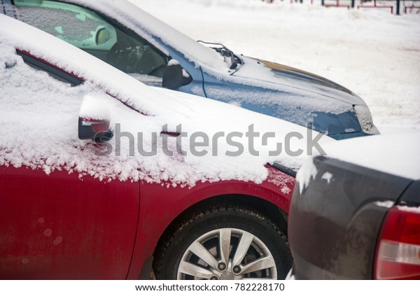 The cars in the Parking lot in the winter. Car\
covered with snow