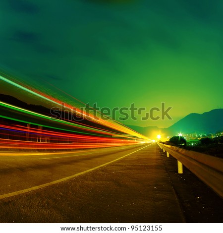 Cars pass on a country road at night