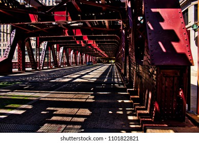 Cars Pass Through Afternoon Shadows Underneath The El Tracks On Wells Street In Chicago Loop.