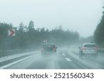 Cars racing down a wet highway in heavy rain