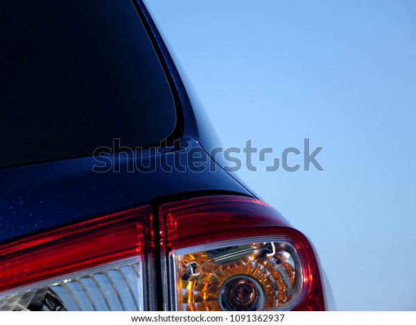 A Cars Rear Window Water Channel, Showing\
the Finished Pressed Steel Panel Covered in Metallic Paint, with\
Blurred Rear Lights on a Blue Sky\
Background