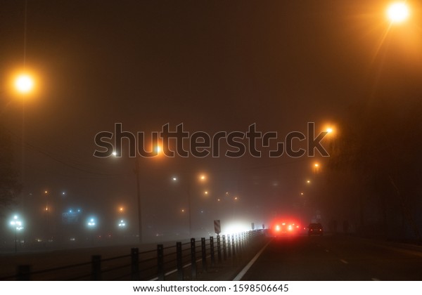 Cars ride in the fog at\
night