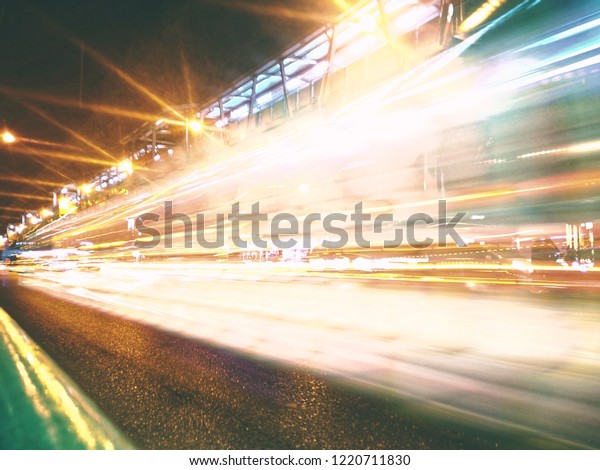 Cars run at night with speed. The light is long\
lines and blurred.