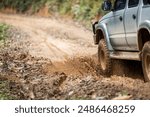 Cars running on off-road roads and splashing mud on natural paths. Off-road travel on muddy road. Suv offroad 4wd car rides through muddy puddle, off-road track road, with a big splash.