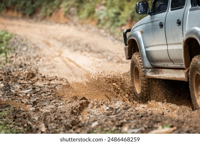 Cars running on off-road roads and splashing mud on natural paths. Off-road travel on muddy road. Suv offroad 4wd car rides through muddy puddle, off-road track road, with a big splash. - Powered by Shutterstock