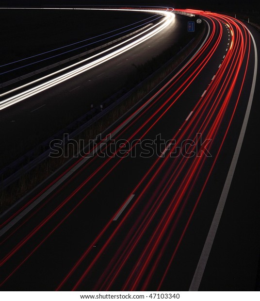 Cars in a rush moving fast on a highway in the UK\
(speedway) at dusk