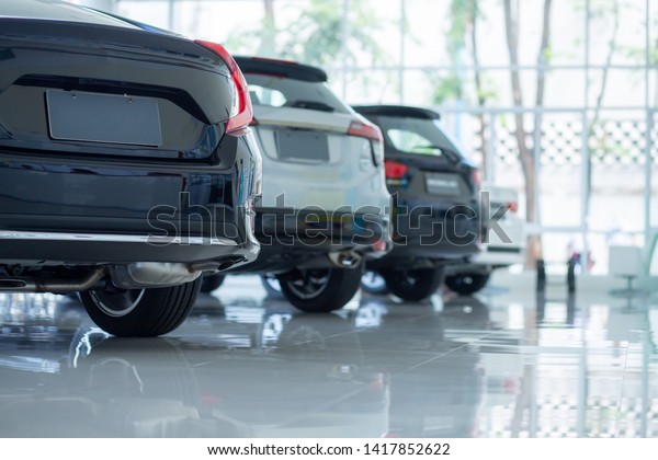 Cars For Sale. Automotive Industry. Cars\
Dealership Parking Lot. Rows of Brand New Vehicles Awaiting New\
Owners in the showroom.