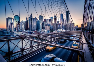 Cars speeding at sunset on Brooklyn Bridge, Manhattan. One of the most iconic bridges in the world, a must see attraction when visiting New York.