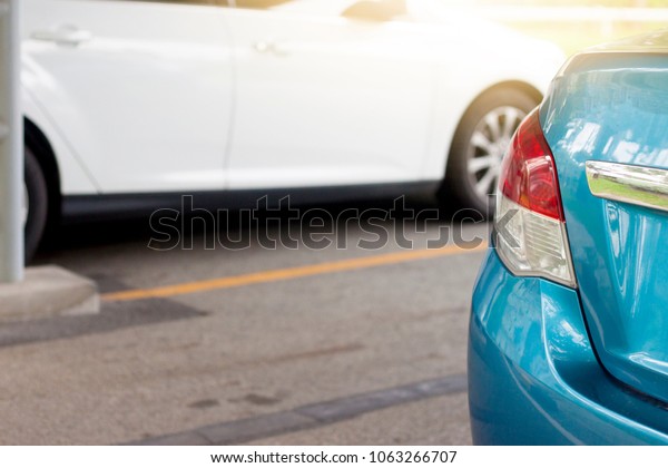Cars stop in parking lot with yellow Road Marking on\
the road and other car.