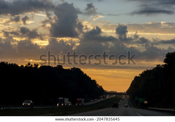 Cars stuck in traffic at dramatic sundown sunset\
time soft focus