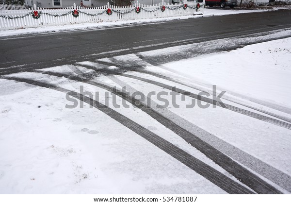 cars and\
tire tracks on the driveway in snowing\
day