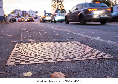 Cars in a traffic congestion in the morning in front of a manhole cover