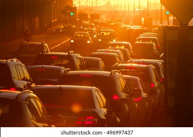 Cars are in traffic jam during a beautiful golden sunset in a big city.