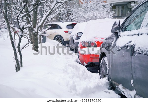 Cars under the snow in the city after\
heavy snowfall. Winter in the city concept.\
Toned.