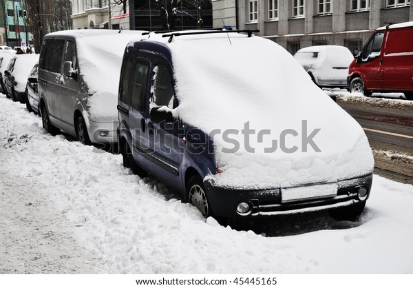 Cars under snow.\
Parked cars under snow.