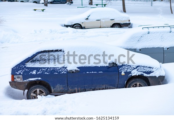 cars under snow Russia.\
Blizzard