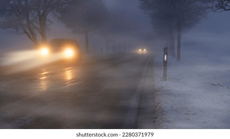 Cars in winter in fog and poor visibility.