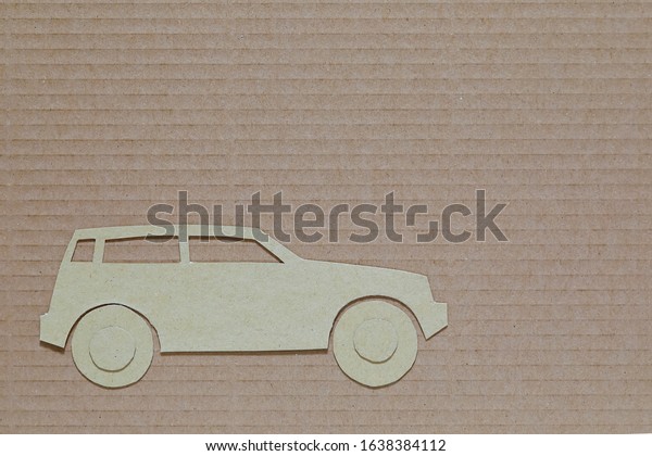 The car-shaped model cut out of\
cardboard is placed against a different type of\
cardboard