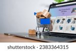 Cart and box icon on laptop computer on white background. Online shopping, marketplace platform website, e-commerce technology, dropshipping, logistics, and online payment concept.