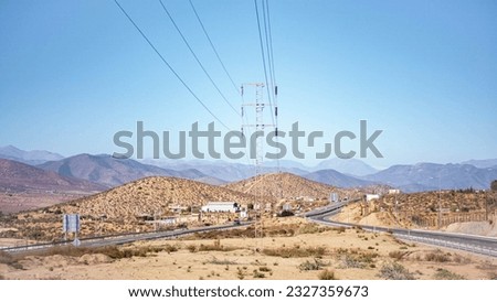 cart in the Chilean desert, high tension towers and power lines under an intense blue sky