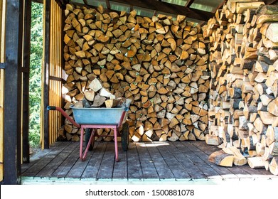A cart with firewood in a firewood storage. Harvesting firewood for the winter.