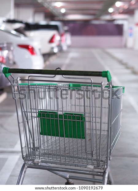 Cart shopping empty blur cars park in supermarket \
background. 