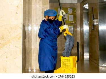 Cartagena, Bolívar/ Colombia; 06/24/2020: Lady With Her Uniform And Mask Face, Doing The Cleaning At The Entrance Of A Building In Times Of Quarantine By The Covid 19.