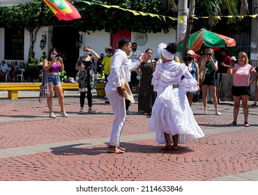 Cartagena, Bolívar, Colombia; 11- 11- 2021: Enthusiastic couple dressed in white dance a Colombian cumbia in the square communicating joy. 