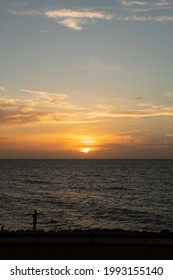 Cartagena De Indias, Bolivar, Colombia - May 30, 2021: A Sunset As Seen From Café Del Mar In Cartagena, Colombia Overlooking The Caribbean Sea With The Silhouette Of A Child Fishing In The Sea.