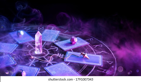 Cartomancy - Pendulum On Blurred Altar With Defocused Tarot Cards
