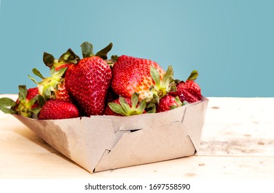 carton box of freshly picked strawberries on wood table - Shutterstock ID 1697558590