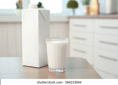 Carton Box And Glass Of Milk On Table In Kitchen