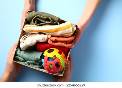 Carton donation box with baby clothes and toy on a color background. Charity concept. - Shutterstock ID 2254666229