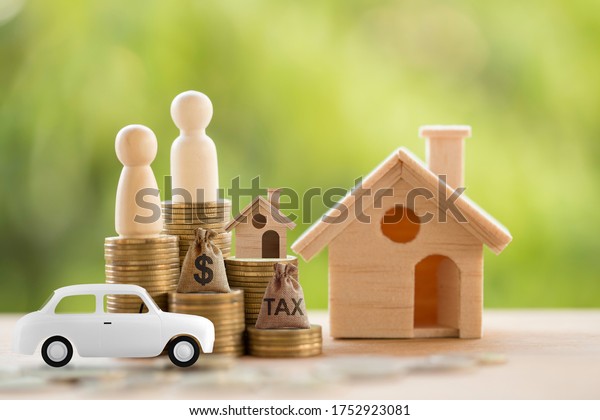Carton model sedan car and rows\
of rising coins with US dollar bags, home, Couple. Concept finance\
and car loan, refinance, cash repayment, Investment and\
business