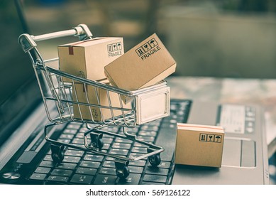 Cartons in a shopping cart on a laptop keyboard. Ideas about online shopping, online shopping is a form of electronic commerce that allows consumers to directly buy goods from a seller over internet. - Shutterstock ID 569126122