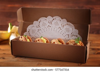 Cartoon Box With Delicious Lemon Ice Cream Cookie Sandwiches On Wooden Table, Closeup