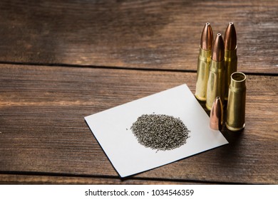 cartridge, bullet, cartridge case and gunpowder on a wooden table