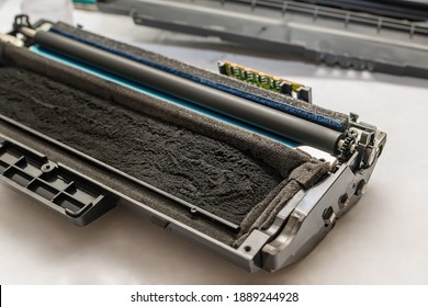 The Cartridge From The Laser Printer, Filled With Toner, Paint, With A Chip, Lies Disassembled On A White Table